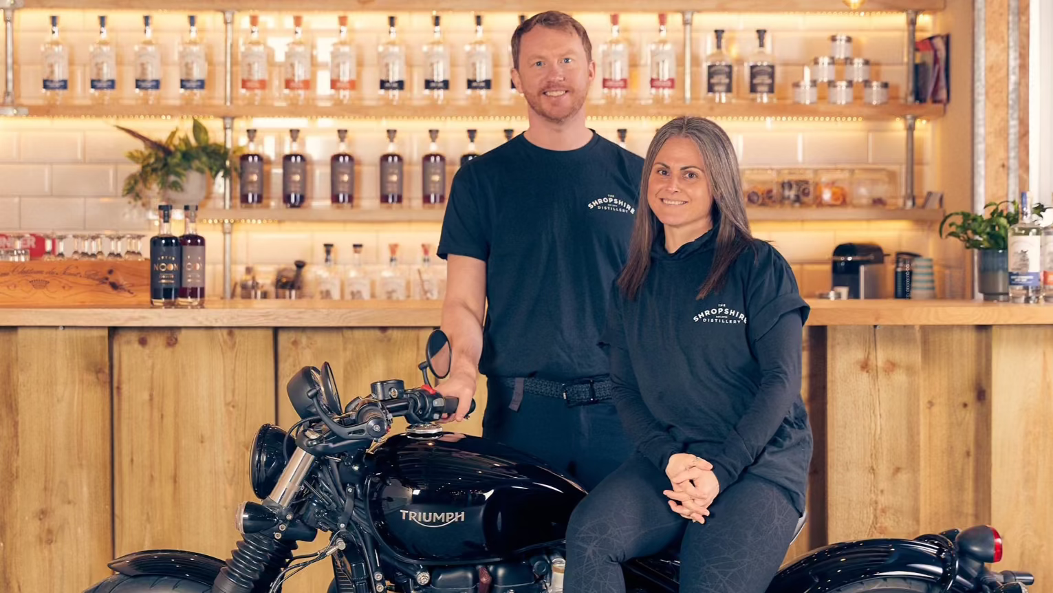 Emma and Gareth with Triumph Bobber at their indecent family owned distillery in Ellesmere, Shropshire